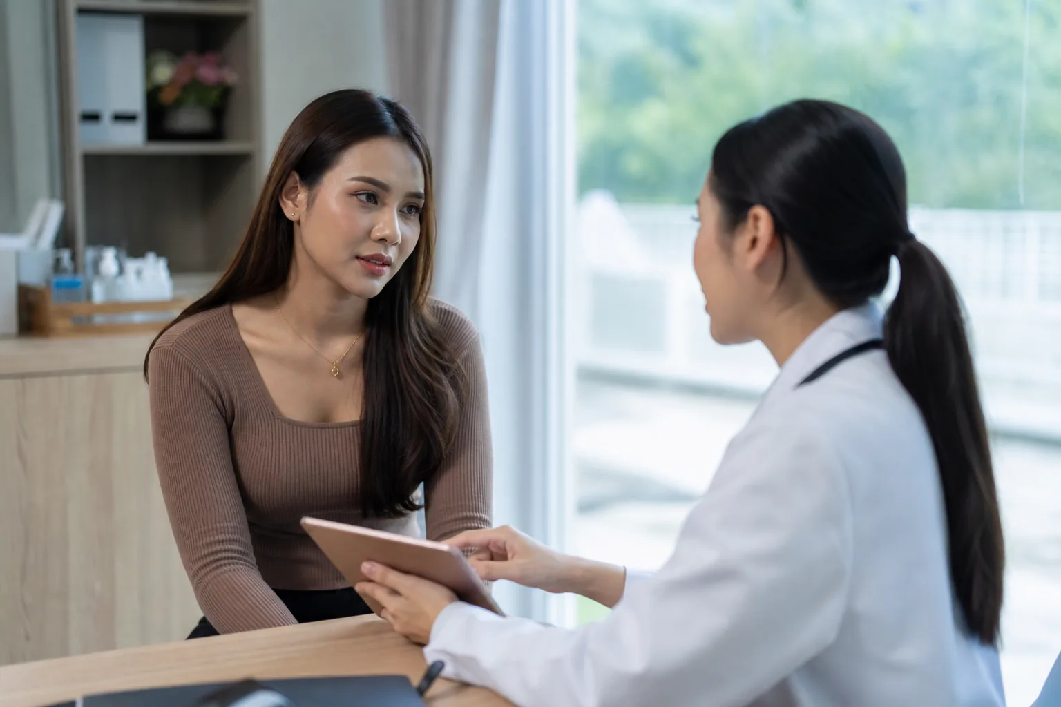 Trans woman talking with a doctor during a clinic consultation